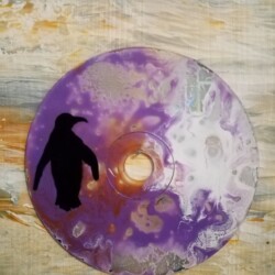 Ombre de pingouin sur fond de peinture fluide O² vus propose une œuvre sur CD recyclé